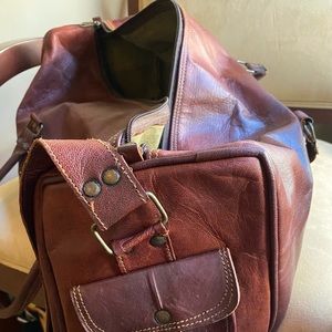 Duffle bag. Leather (brwn/burgundy). Side and front pockets with strap.